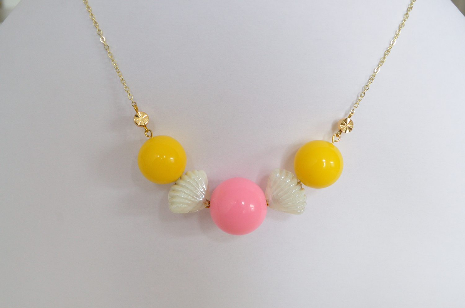 fine, gold-plated necklace with gold-plated spacers, chunky acrylic beads in pink and yellow and white shell glass beads
