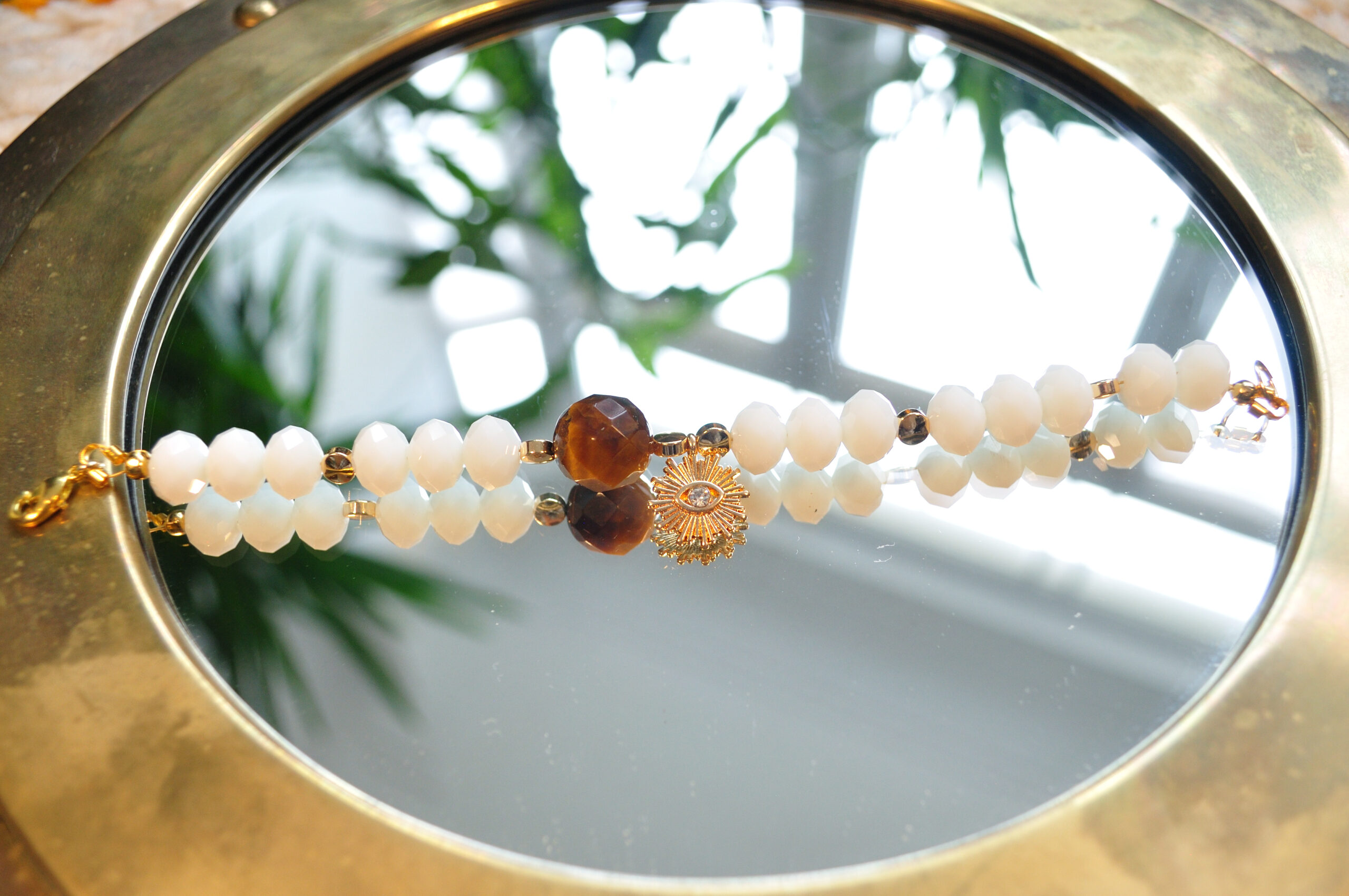 summery bracelet in white, gold and brown with tiger's eye and brass and crystal eye pendant