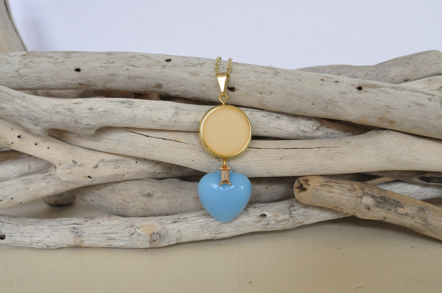 fine, gold-plated necklace with light blue heart pendant and off-white round bead with golden rim