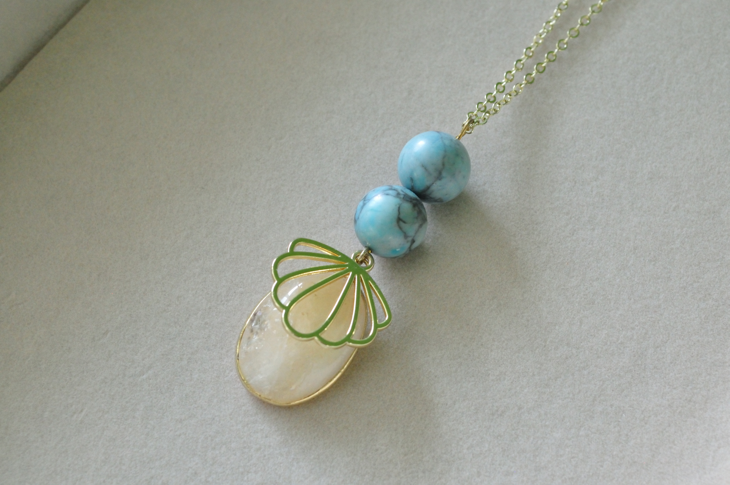 fine, gold-plated necklace with light blue Howlite, Quartz Cabochon and stylised shell pendant